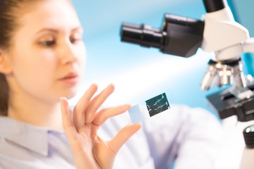 Canvas Print - woman in a laboratory microscope with microscope slide in hand