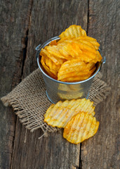 potato chips in a bucket on wooden surface