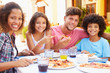 © Monkey Business - Portrait Of Family Eating Meal At Outdoor Restaurant