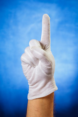 Hand in white glove showing one finger