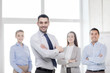 © Syda Productions - smiling businessman in office with team on back