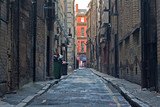 Fototapeta Uliczki - Looking down an empty inner city alleyway