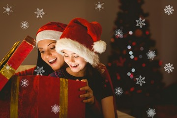 Mother and daughter opening a christmas gift