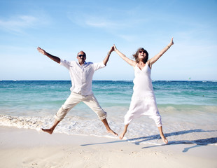 Wall Mural - Happy couple jumping on beach