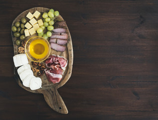 Wine appetizers set: meat and cheese selection, honey, grapes, w