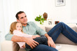 © W PRODUCTION - happy handsome young daddy and young daugther on sofa at home