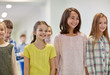 © Syda Productions - group of smiling school kids walking in corridor