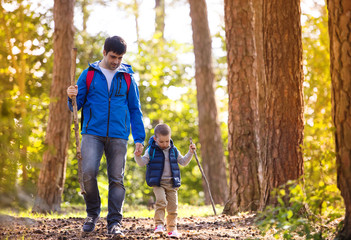 Father and son walking in autumn forest