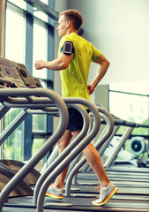 Poster - man with smartphone exercising on treadmill in gym