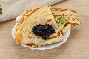 Pancakes with black caviar