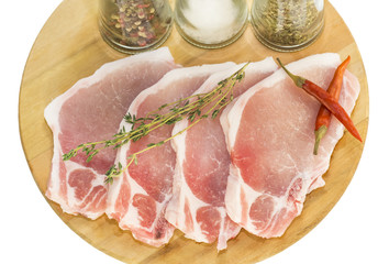 raw pork steaks on a cutting board