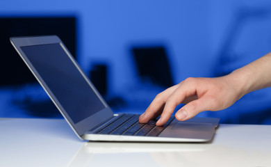 Businessman pressing modern laptop computer on colorful backgrou