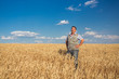 © Ryzhkov Oleksandr - farmer standing in a wheat field