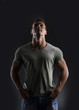© theartofphoto - Handsome muscular fit young man on dark background looking up