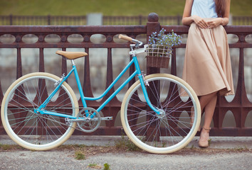 Young beautiful, elegantly dressed woman with bicycle