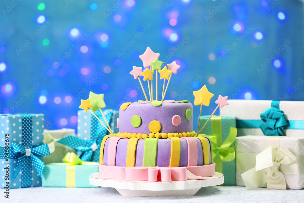 Delicious birthday cake on shiny blue background