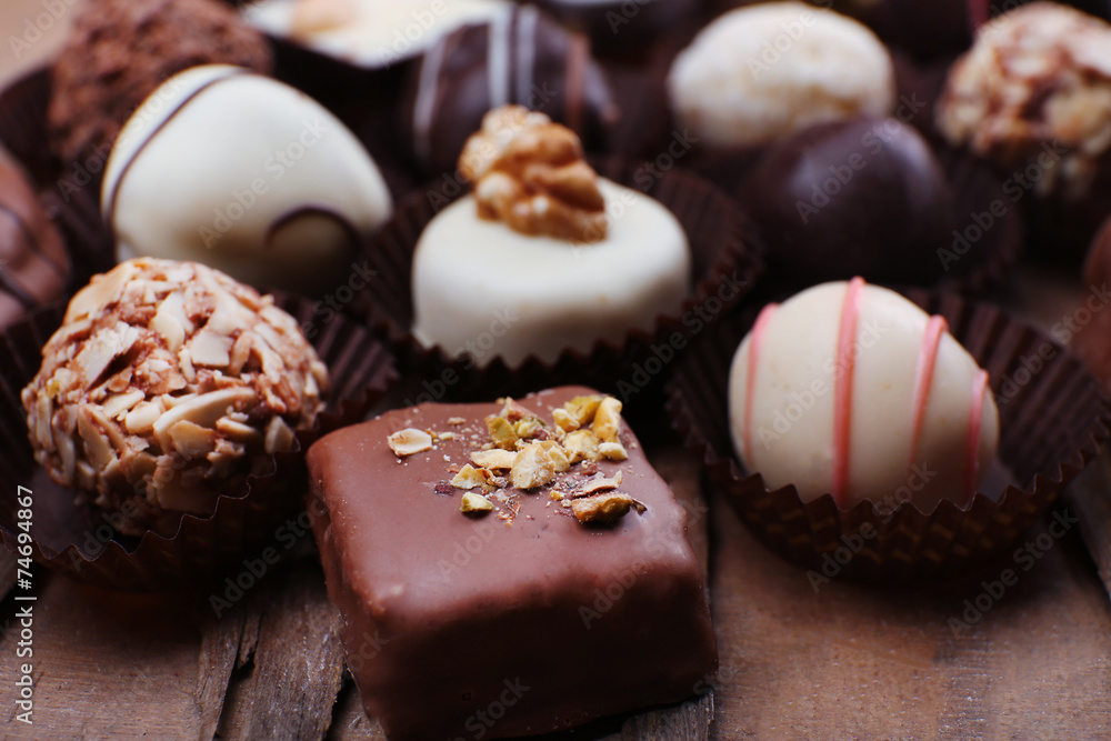 Many chocolates on wooden textured background