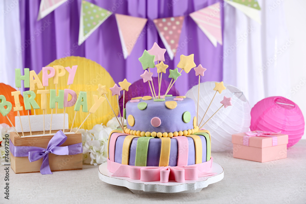 Delicious birthday cake on table on bright background