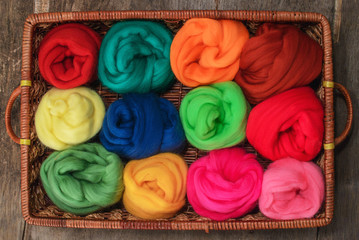 Wall Mural - colored skeins of wool felting in a wicker tray