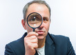© slasnyi - Businessman looking through magnifying glass