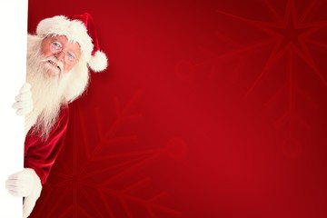 Poster - Composite image of santa looks out behind a wall