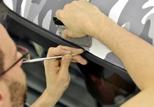Car Wrapping Specialist Wraps A Car Parts With Adhesive Foil
