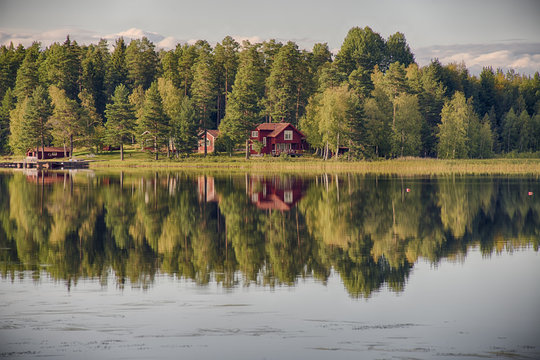 summer in sweden - traditional red cottage at a lake