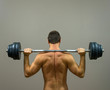 © M-Production - Muscular man doing exercises with barbell. Back view.