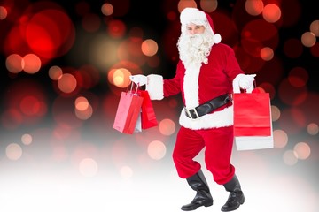 Poster - Composite image of smiling santa claus holding shopping bags