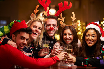 group of friends enjoying christmas drinks in bar