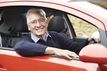 Portrait Of Smiling Senior Man Driving Car