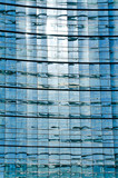 Glass Facade of company building with reflection of blue sky.