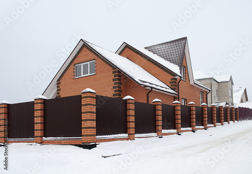 Snow Covered Red Brick House With Metal Fence Buy This Stock