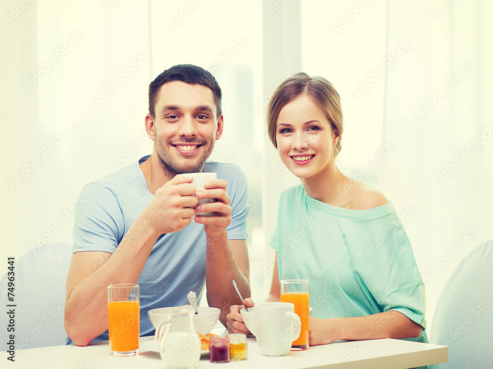 smiling couple having breakfast at home
