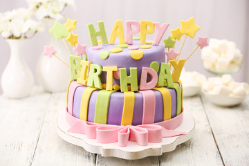 Wall Mural - Delicious birthday cake on table on light background