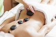 Young woman having a hot stone massage therapy