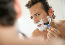 Mature Handsome Man Shaving In Front Of Mirror