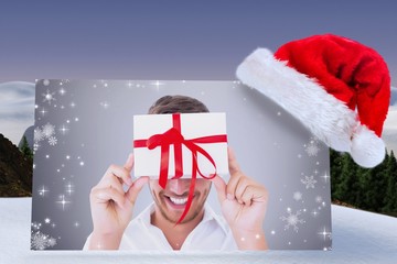 Poster - Composite image of man holding gift