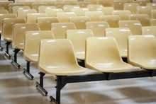 Empty Yellow Plastic Chairs In Many Rows