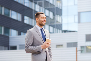 Canvas Print - young serious businessman with paper cup outdoors