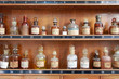 medicamentos antiguos colocados en una estantería de madera farmacia 7224-f14