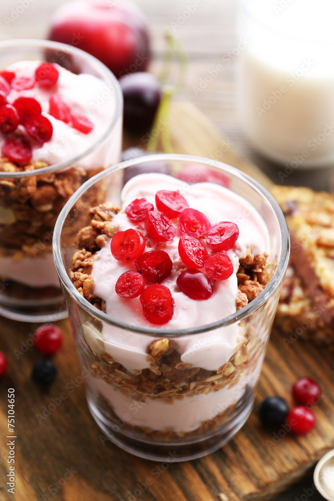 Healthy layered dessert with muesli and berries on table