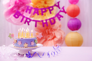 Delicious birthday cake on table on bright background