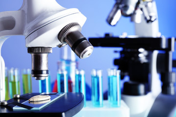 Wall Mural - microscopes and test tubes on table, on color background