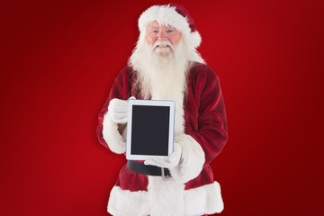 Poster - Composite image of santa presents a tablet pc