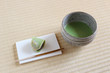 日本の畳に置いた抹茶の入った茶碗と和菓子