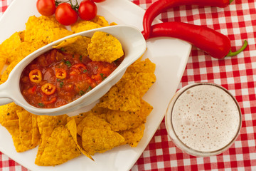 Spicy red salsa with tortilla chips and beer