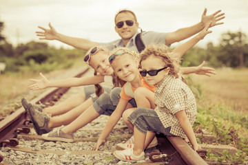 Happy family walking on the railway at the day time.