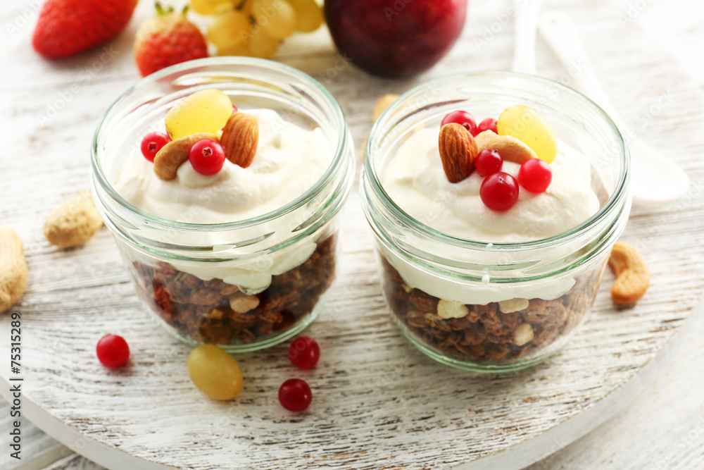 Healthy layered dessert with muesli and berries on table