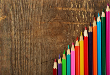 Sticker - Colorful pencils on rustic wooden background